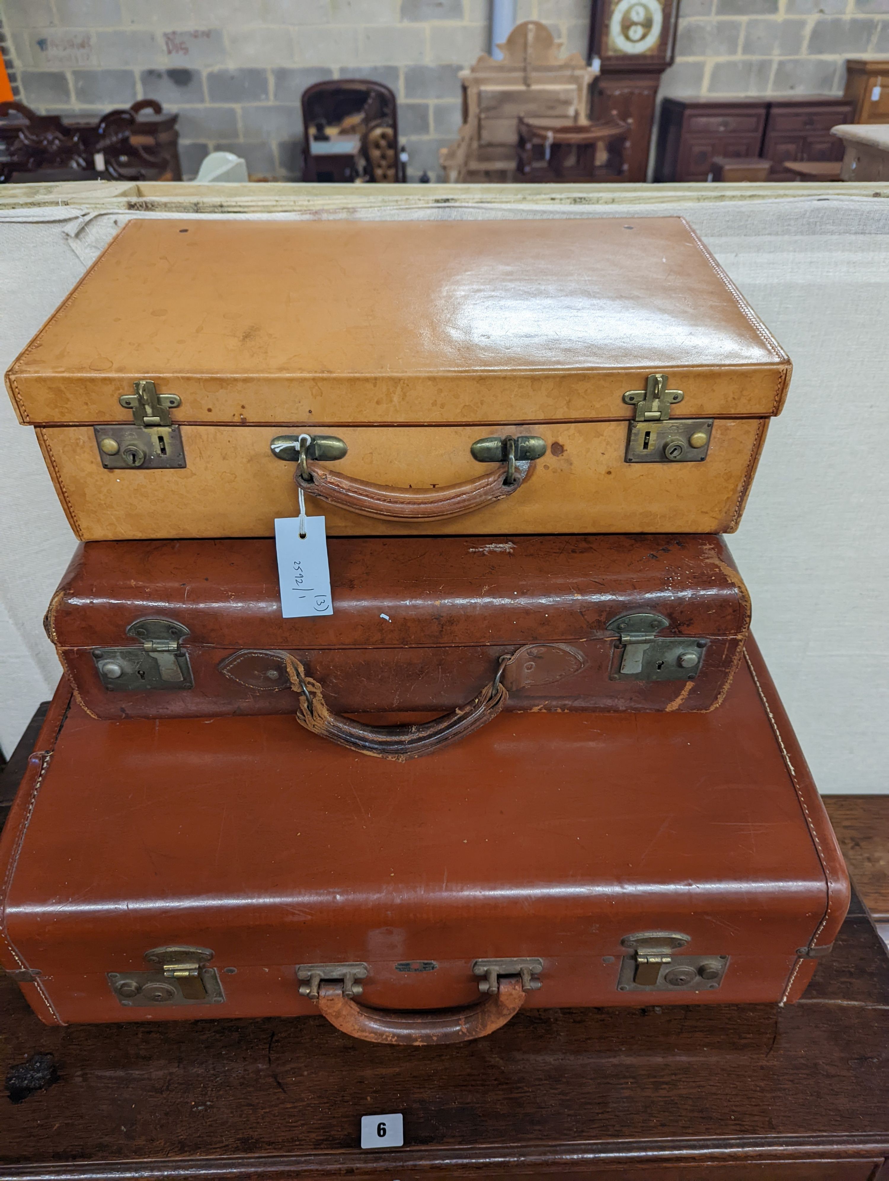A vintage tan leather case, marked 'Tom Hill SW1' together with two other vintage cases, largest width 61cm, depth 46cm